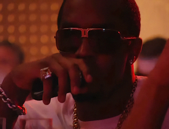 Diddy wearing sunglasses and jewelry at a party, related to Britney Spears wild party mentioned during trial.