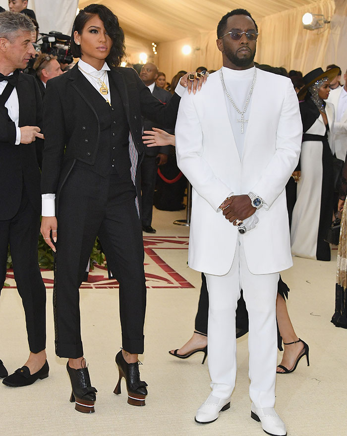 Cassie and Diddy dressed in black and white suits at a formal event, highlighting freak-offs and graphic details.