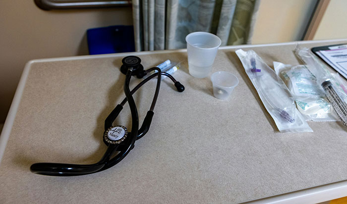 Stethoscope and medical supplies on a hospital table representing symptoms needing immediate medical attention.