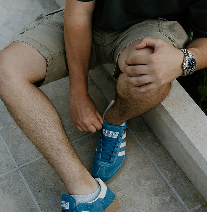 Person sitting outdoors holding knee, illustrating symptoms that can seem harmless but need immediate medical attention.
