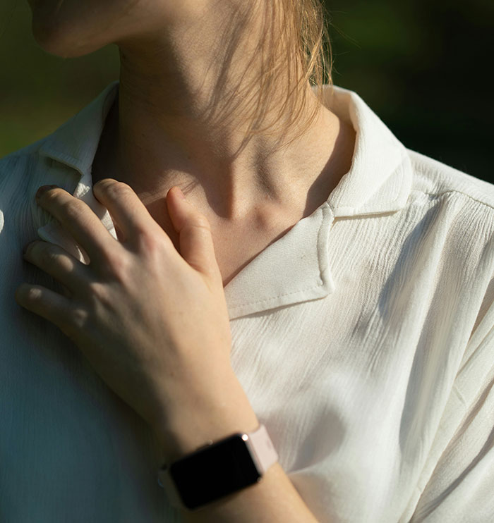 Person touching neck showing symptoms that can seem harmless but require immediate medical attention.