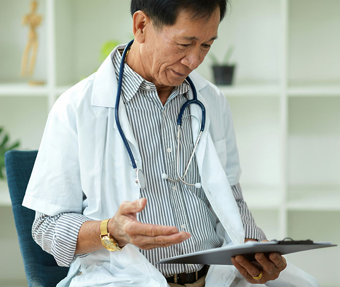 Doctor reviewing medical symptoms on a clipboard, highlighting symptoms that require immediate medical attention.