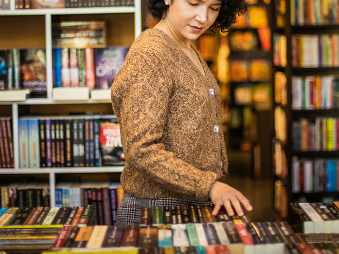 Woman browsing books in a bookstore, illustrating moments when people didn’t know someone could be so stupid.