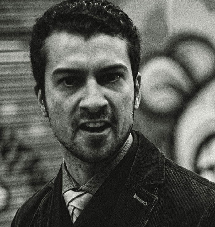 Young man with intense expression in monochrome photo, illustrating emotional signs people missed while being cheated on.