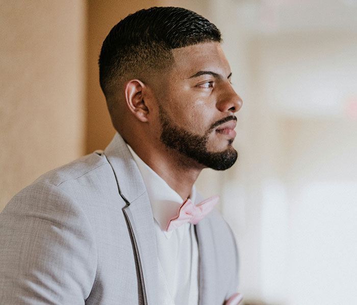 Young man in a light suit gazing thoughtfully, illustrating signs missed while being cheated on in relationships.