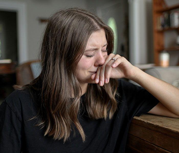 A woman showing signs of emotional pain and pulling away after realizing she was being cheated on.