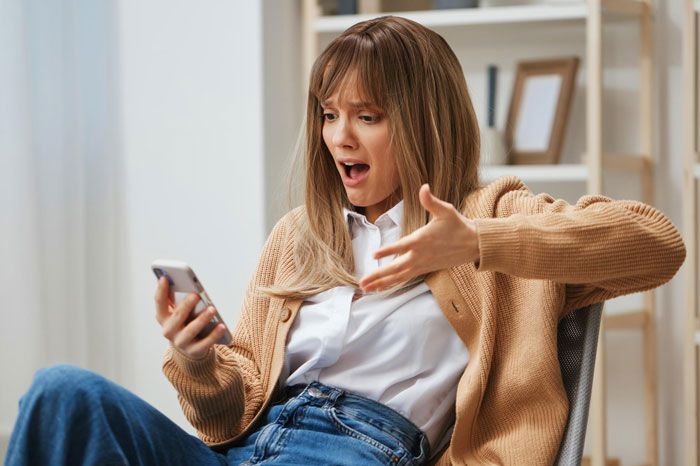 Woman in casual clothes looking shocked at phone, reacting as girl's 11th birthday turns sour with demands for cake and gifts Woman in casual clothes looking shocked at phone, reacting as girl's 11th birthday turns sour with demands for cake and gifts