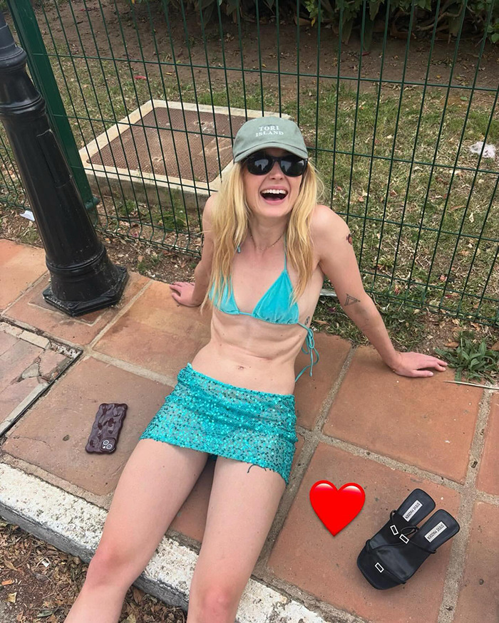 Sophie Turner sitting outdoors in a turquoise bikini and skirt, showing muscular physique and smiling with sunglasses and a cap. Sophie Turner sitting outdoors in a turquoise bikini and skirt, showing muscular physique and smiling with sunglasses and a cap.