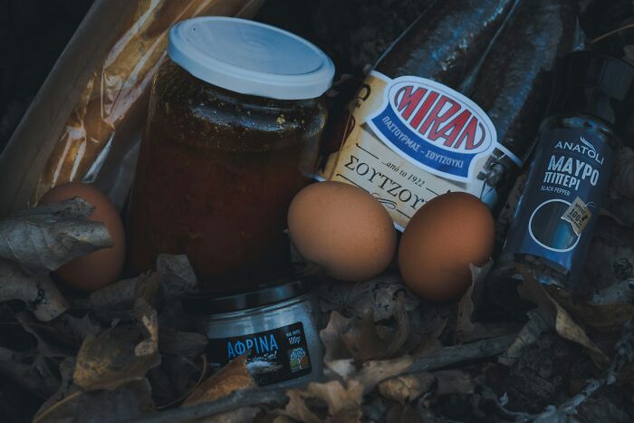 Assortment of food items including eggs, bread, spices, and jars placed on a rustic surface revealing appalling facts people unaware.