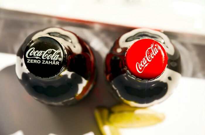 Two Coca-Cola bottles next to French fries, highlighting how French fries and Diet Coke may treat a migraine.