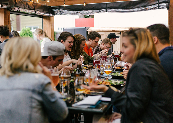 Group of women enjoying food and drinks outdoors, illustrating things women stopped pretending they like after 30.