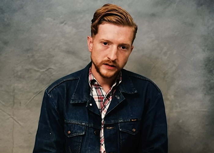 Young man in denim jacket sharing stories as people who knew celebrities before fame reveal what they were like.