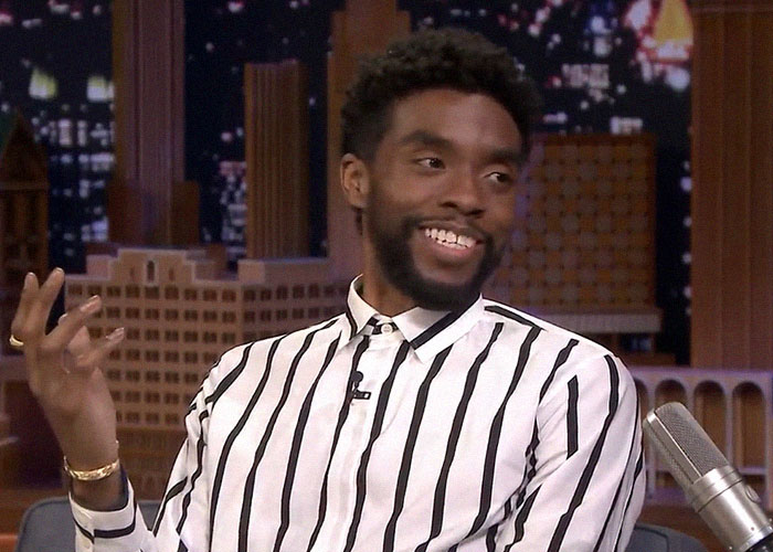 Man in a striped shirt smiling and gesturing during a talk show, sharing stories about people who knew celebrities before fame.