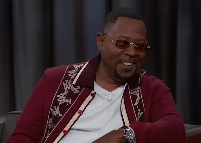 Man wearing sunglasses and a maroon jacket smiling during an interview about people who knew celebrities before fame.