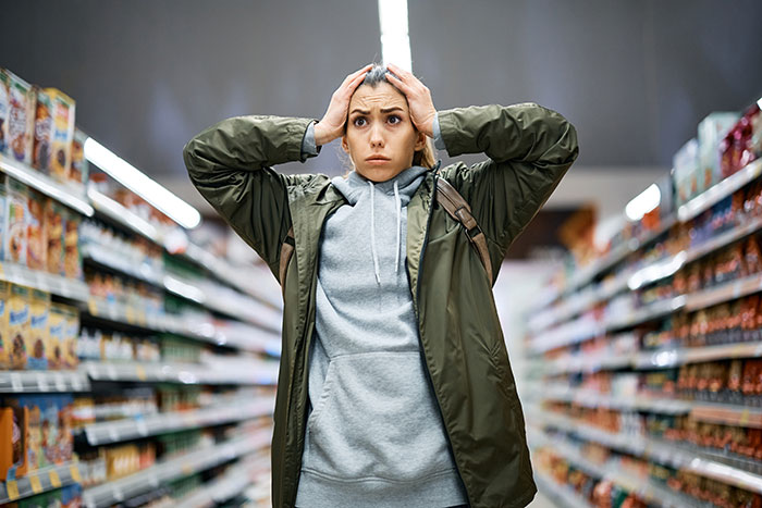 Woman in a store looking shocked and concerned after almost getting scammed, learning a valuable lesson about scams. Woman in a store looking shocked and concerned after almost getting scammed, learning a valuable lesson about scams.