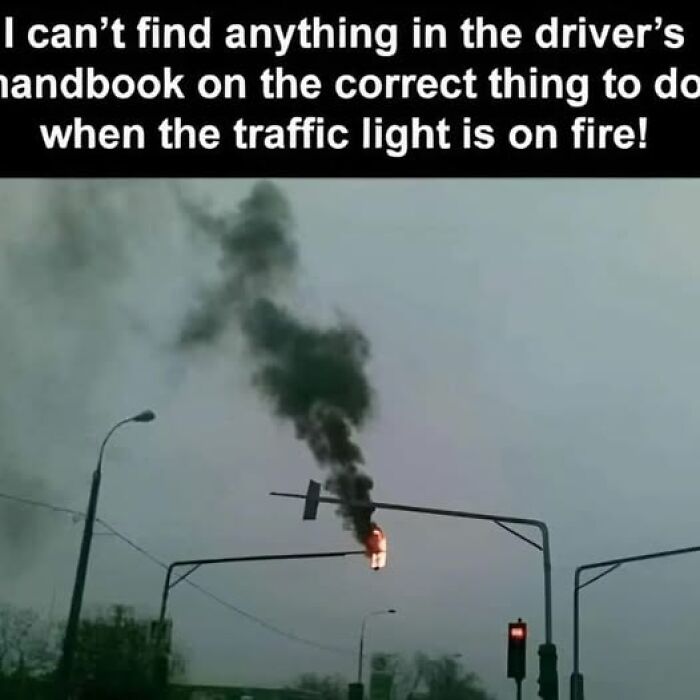 Traffic light on fire with smoke rising, illustrating a random meme for when your brain needs a break from stress.