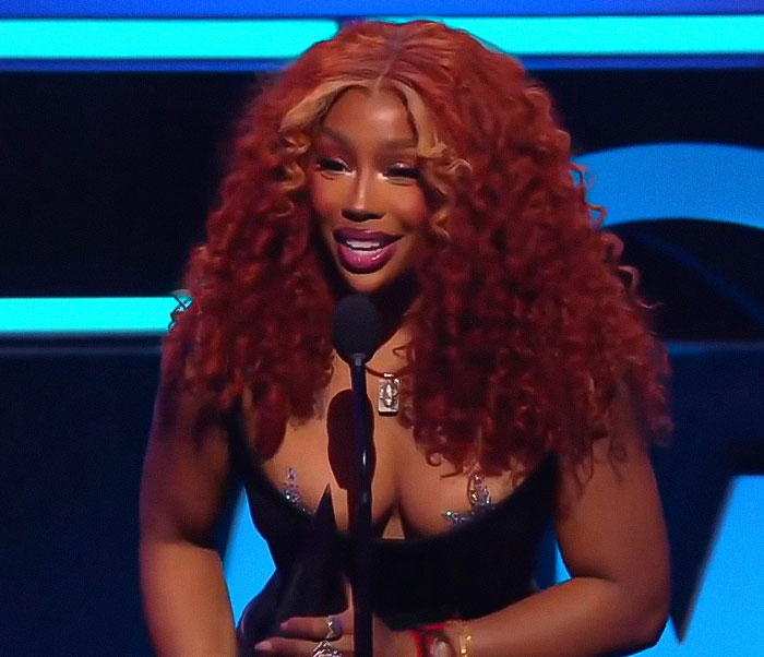 Woman with long curly red hair speaking at 2025 AMAs, capturing the most cringeworthy moments of the award show.