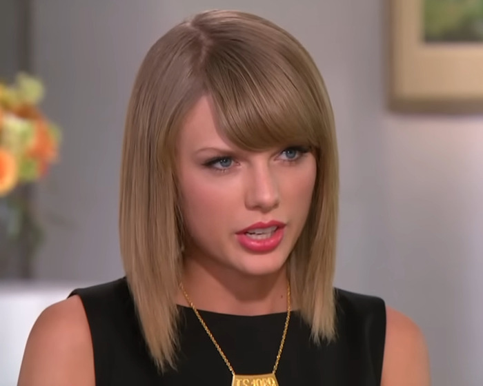 Taylor Swift during a candid interview, wearing a black top and gold necklace, discussing a brutal interrogation moment. Taylor Swift during a candid interview, wearing a black top and gold necklace, discussing a brutal interrogation moment.