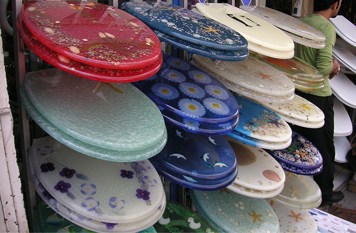 Colorful decorated surfboards displayed in a shop, illustrating unique gifts from partners as red flag examples.