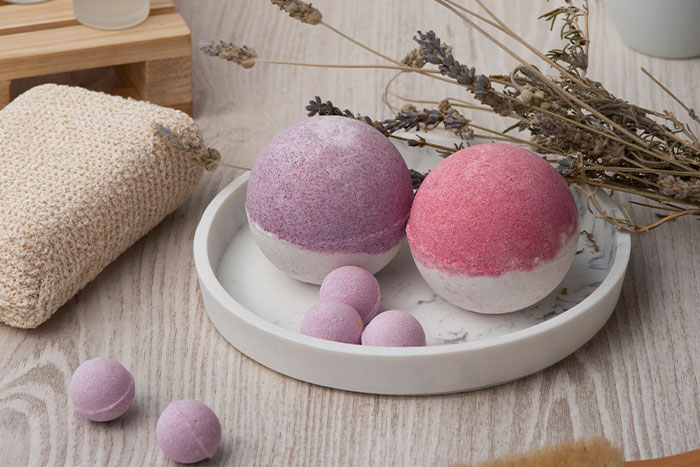 Bath bombs and dried lavender arranged on a tray with a washcloth, illustrating red flag gifts from partners.
