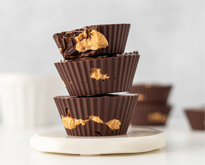 Stacked chocolate peanut butter cups with bites taken out, illustrating gifts as a red flag in relationships.