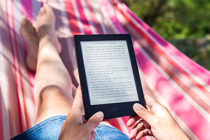 Person relaxing in a hammock reading on an e-reader, illustrating the concept of terrible gifts from partners.