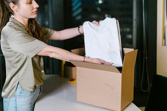 A woman unpacking a box of gifts from her partner, symbolizing red flag signs in relationships after divorce.