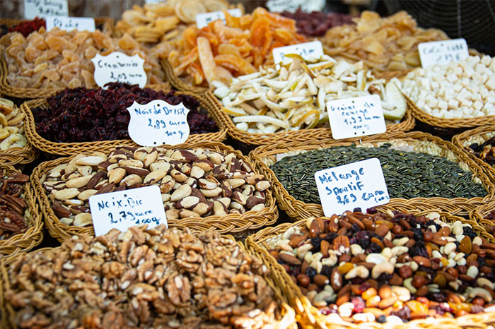 Baskets of various nuts and dried fruits displayed with labels, illustrating examples of terrible gifts from partners.