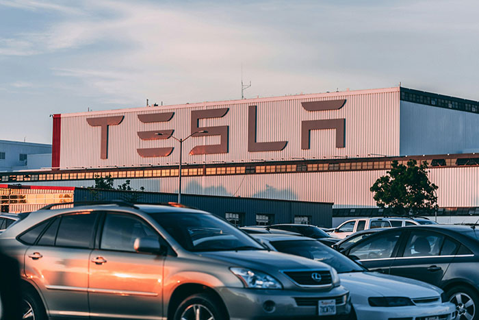 Tesla factory building with large logo visible, illustrating Tesla searches for new CEO to replace Elon Musk.