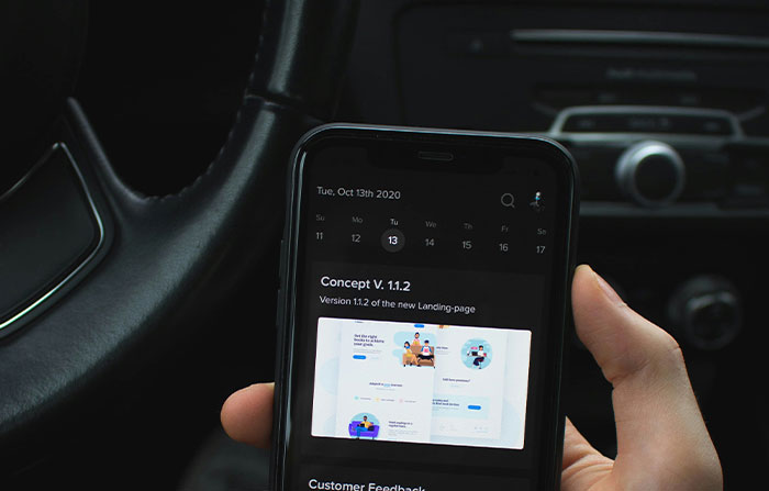 Person holding smartphone inside a car showing a digital calendar app, highlighting potential life-changing moments in seconds.