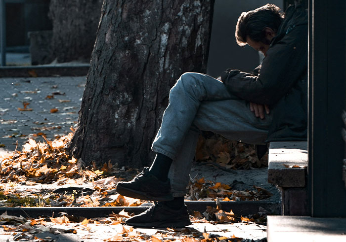 Man sitting alone on steps in autumn, illustrating the impact of things that could completely destroy lives in seconds.