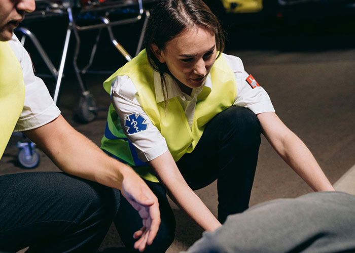 Emergency personnel in reflective vests providing urgent care during a nighttime medical emergency response scene