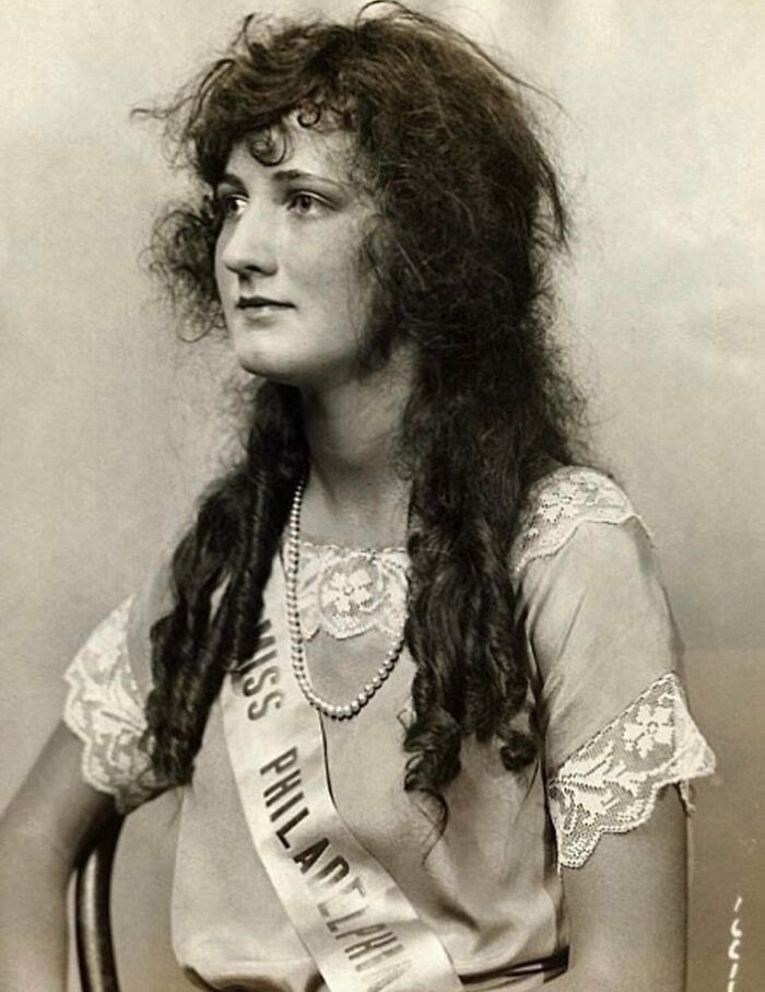 Vintage photo of a young woman with long curly hair wearing a Miss Philadelphia sash and lace dress, showing history up close.