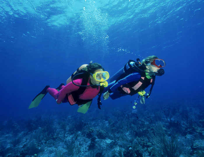 Two scuba divers underwater exploring the ocean, an experience that made people say never doing that again.