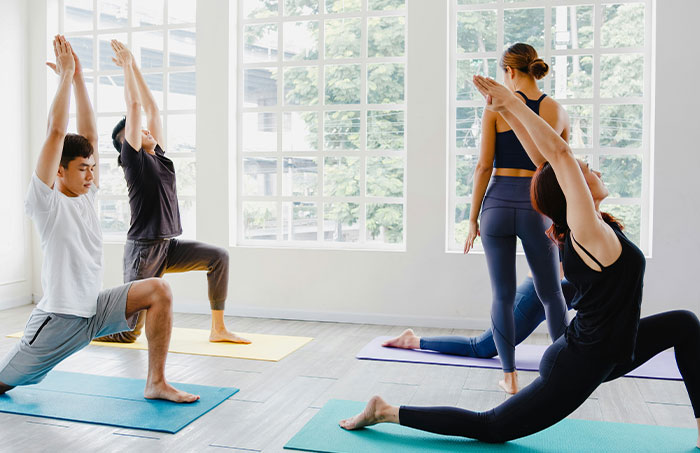 Group of people practicing yoga indoors, illustrating experiences that made people say never doing that again.