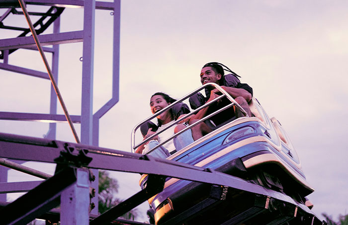 Two people on a roller coaster ride experiencing thrilling moments, one of 45 experiences that made people say never doing that again.