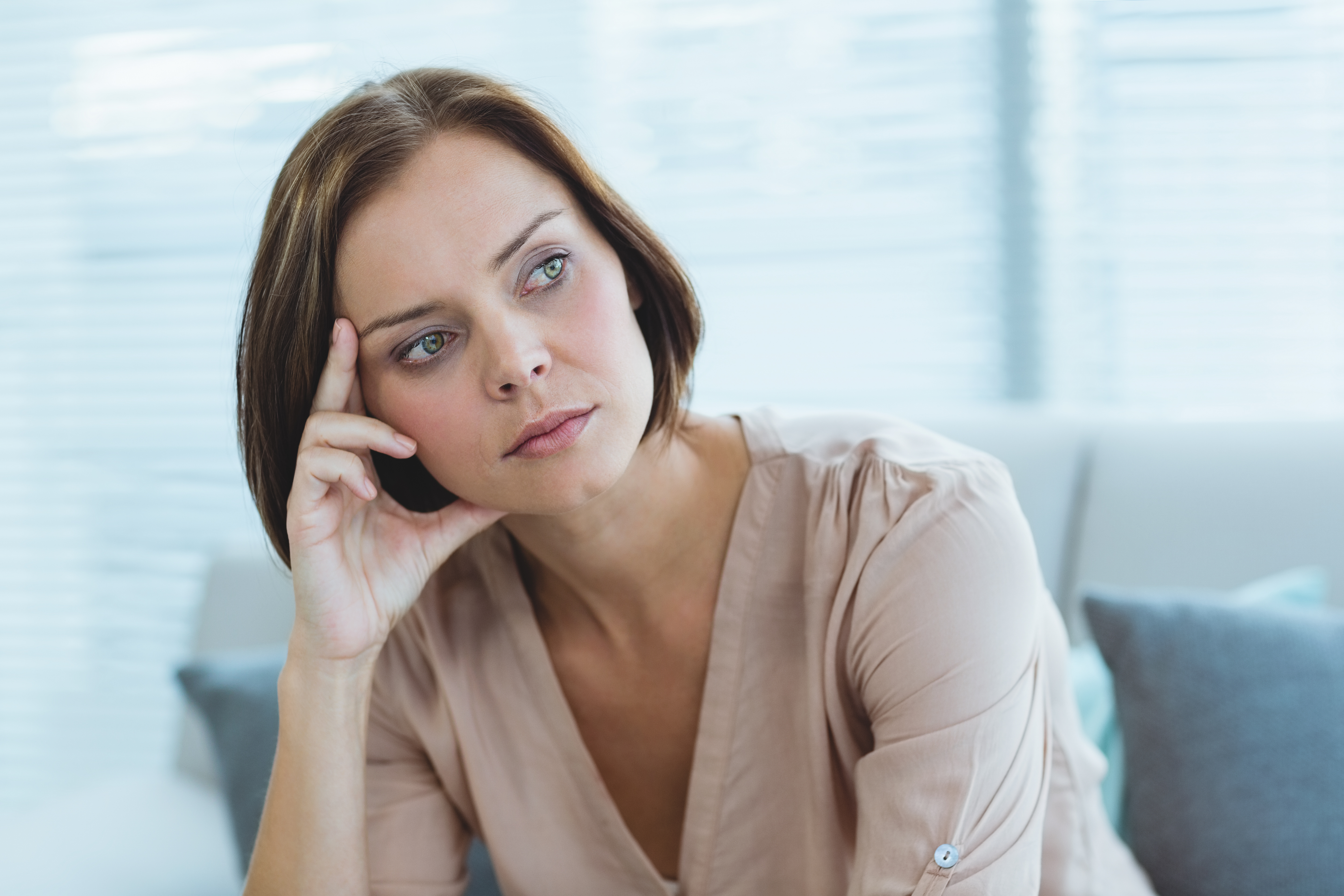 Thoughtful woman sitting indoors, reflecting on a difficult moment involving her husband&rsquo;s childhood best friend favor request.
