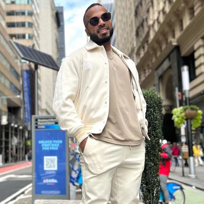 Man wearing sunglasses and cream outfit standing on a city street, related to toddler found covered in blood news.