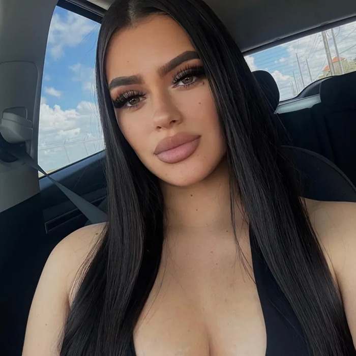 Young woman with long dark hair in a car, representing influencer connected to toddler found covered in blood incident.
