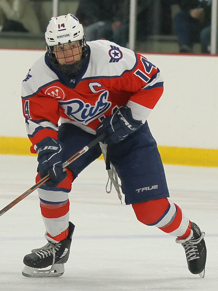 Female athlete on ice in hockey gear, focused during a game, illustrating issues faced by female athletes in sports.