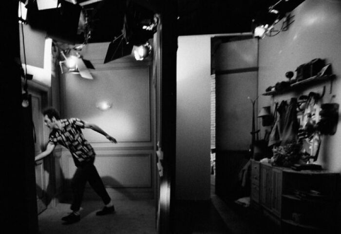 Man captured in an alternate angle behind the scenes of an iconic historical event setup in black and white.