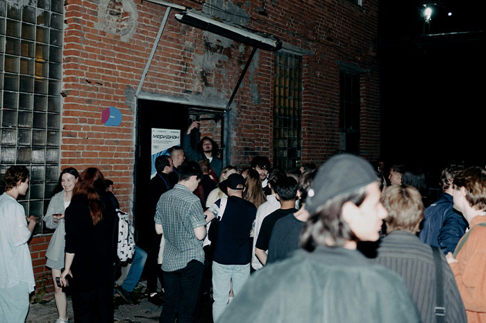 A group of people gathered outside a brick building at night, illustrating wild analogies healthcare workers use.