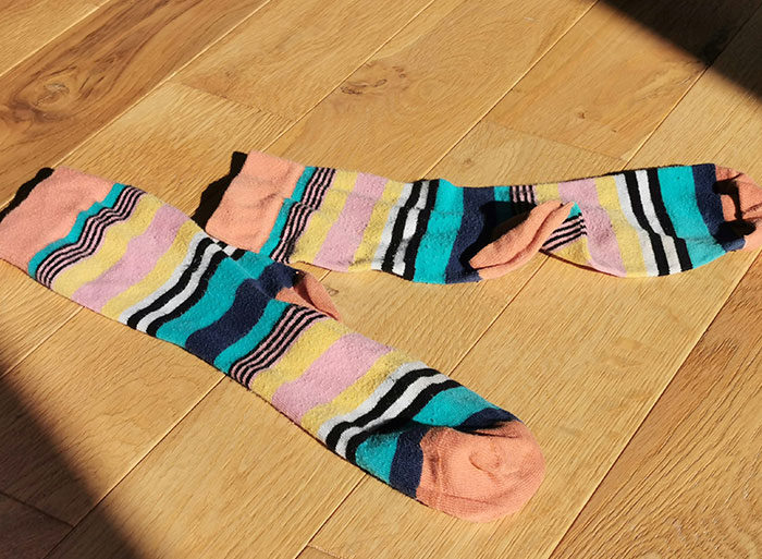 Colorful striped socks laid out on wooden floor illustrating analogies healthcare workers use to explain medical problems