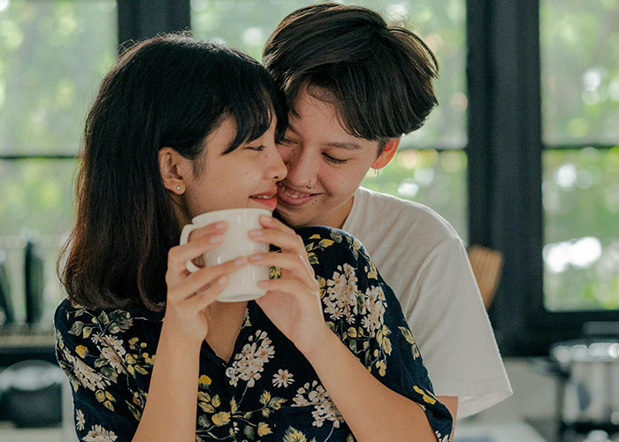 Couple sharing a tender moment indoors, highlighting emotions tied to unknowingly paying rent to husband and his mom.