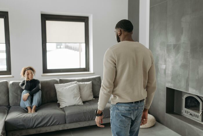 Husband refusing to help check on elderly parents’ home while wife sits on couch looking concerned. Husband refusing to help check on elderly parents’ home while wife sits on couch looking concerned.