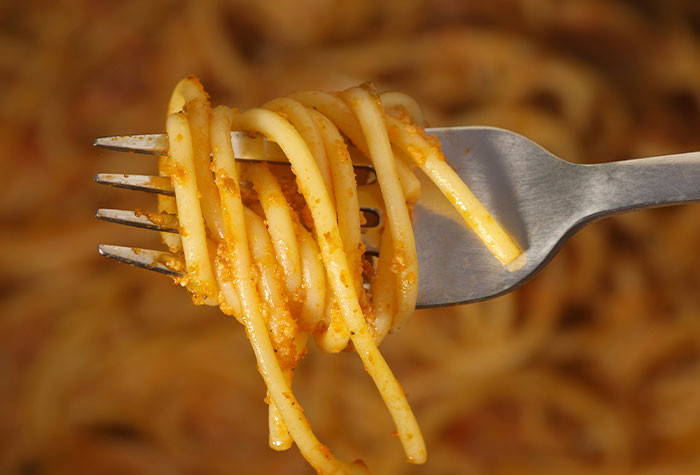 Fork holding spaghetti with sauce, illustrating common cooking advice that doesn't really do anything.