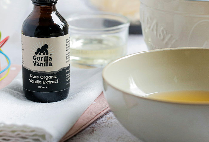 Bottle of vanilla extract next to a bowl and glass, illustrating common cooking advice that doesn't really do anything.
