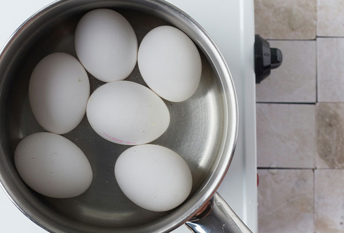 Pot of eggs on stove with water, illustrating common cooking advice and tips that may not be effective.
