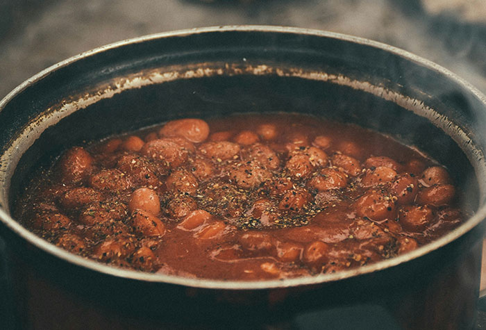 Close-up of a pot with simmering beans and spices, illustrating common cooking advice and kitchen tips.