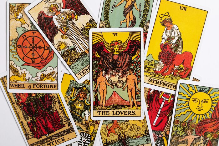 Various tarot cards including The Lovers, Wheel of Fortune, and Strength, used in weird ways to earn quick money.